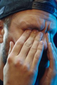 Tired person rubbing eyes in the morning – Common reasons you wake up sore and how to fix it